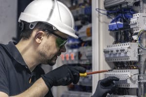 male electrician works switchboard using electrical connection cable